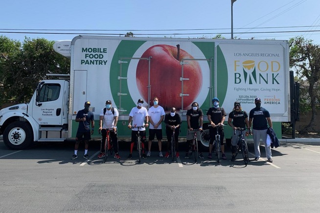 Members of the baseball team, along with head coach Vic Buttler's cycling group, helped distribute food at Cerritos College to those in need.
