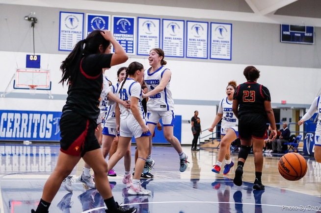 Teammates celebrate with Rayne Rodriguez (10), who scored the game-winning basket at the buzzer